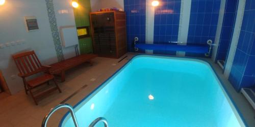 Batelov巴泰洛夫公寓的浴室设有游泳池、长凳和椅子