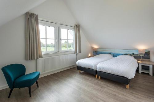 诺德韦克布特恩普拉特斯维特拉弗昂兹酒店的卧室配有床、椅子和窗户。
