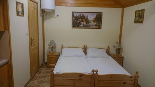 GyékényesKéktó Kemping的一间卧室配有木床和2个床头柜