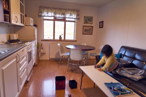 瓦玛里德Solvanes Farmholidays的坐在厨房沙发上的小女孩