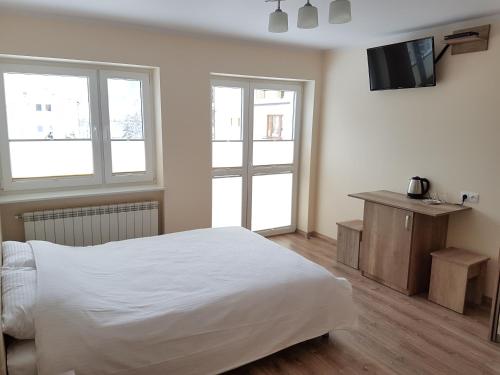 克雷尼察Willa RYŚ的卧室配有白色的床和2扇窗户。