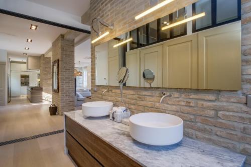 木洛希尼Apartments Argemonia的砖墙上带两个水槽的浴室