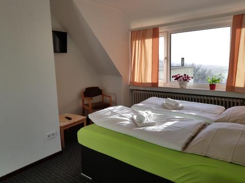 巴特恩豪森Berghotel的一间卧室设有一张大床和窗户