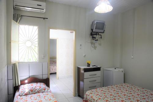 马塞约Pousada Belo Mar的卧室配有一张床,墙上配有电视。