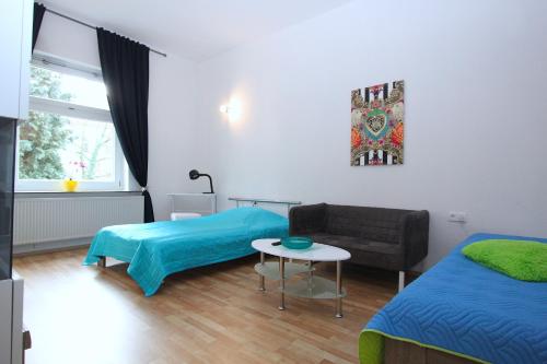 汉诺威Bothmers Eck的客房设有两张床、一张沙发和一张桌子。