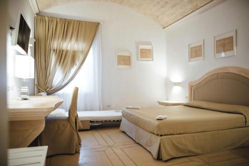 福贾La Magione的一间卧室设有两张床、一张桌子和一个窗口。