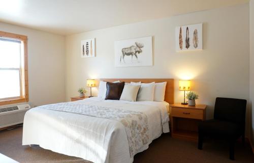 西黄石The Aspen的卧室配有一张白色大床和一把椅子