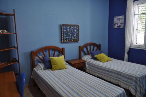 GüimeVilla Miramar, Güime的蓝色墙壁客房的两张床