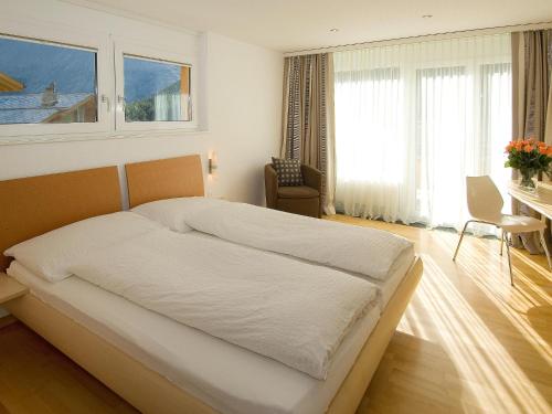 萨斯费多尔斯维塔公寓的卧室配有一张白色大床、书桌和窗户。