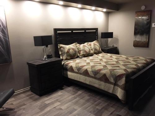 德拉蒙德维尔Travelodge by Wyndham Drummondville的一间卧室配有一张带2个床头柜和2盏灯的床。