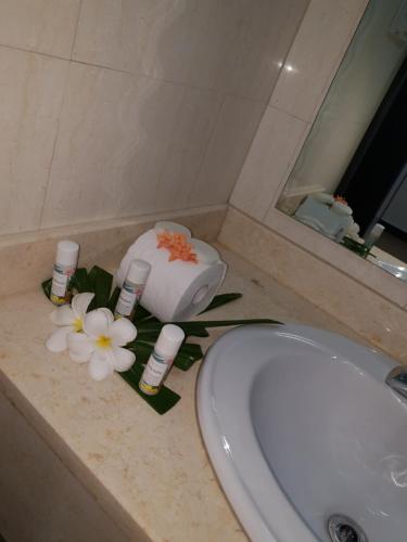 南迪Nasau Resort & Villas的浴室柜台配有水槽和鲜花
