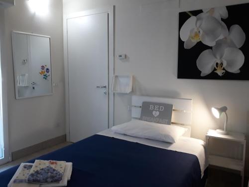 罗扎诺艾玛住宿加早餐旅馆的卧室配有蓝色和白色的床和镜子