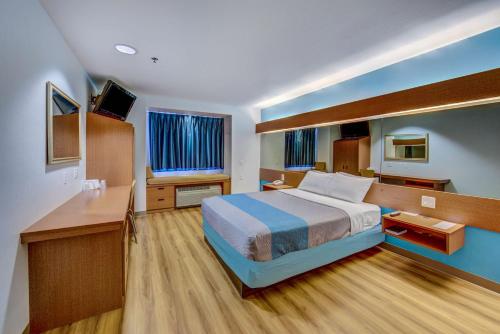 Sutherlin萨利客居套房酒店的配有一张床和一张书桌的酒店客房