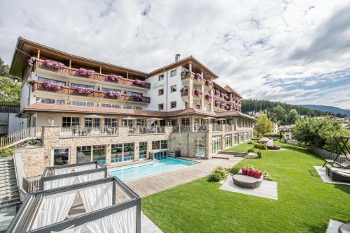 佩尔卡Hotel Waldhof的享有带游泳池的建筑的外部景色
