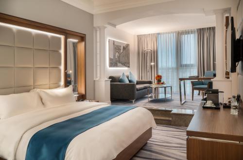 安曼安曼华厦酒店及会议中心的酒店客房设有一张大床和一间客厅。