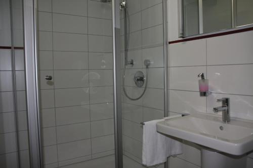 诺德海姆市场Wirtshaus am Markt的带淋浴和盥洗盆的白色浴室