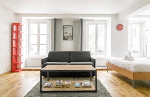 巴黎50m2 rue rambuteau/Pompidou/Marais/Hôtel de Ville的客厅配有沙发和1张床