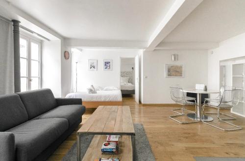 巴黎50m2 rue rambuteau/Pompidou/Marais/Hôtel de Ville的客厅配有沙发、桌子和床。