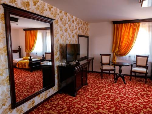 新瓦罗什Hotel Zlatarski Zlatnik的酒店客房带镜子和卧室