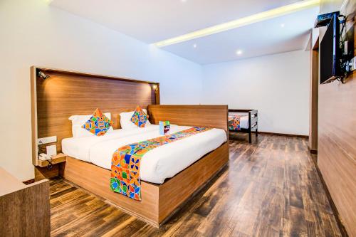 科代卡纳尔FabHotel Tranquil Heights Kodaikanal的一间卧室配有一张大床和一台平面电视