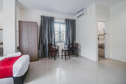 巴淡岛中心RedDoorz @ Baloi Batam的卧室配有一张床和一张桌子及椅子