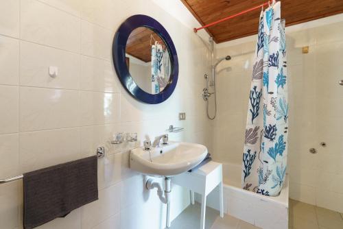 多马索bungalow campeggio madonnina的一间带水槽、镜子和淋浴的浴室