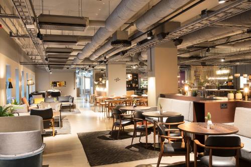 斯德哥尔摩Comfort Hotel Kista的一间带桌椅的餐厅和一间酒吧