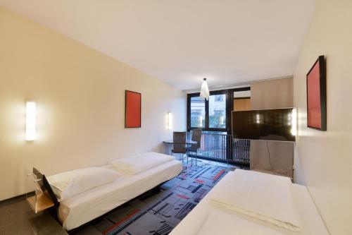 汉诺威威耶堡酒店的一间卧室配有一张床、一张书桌和一台电视