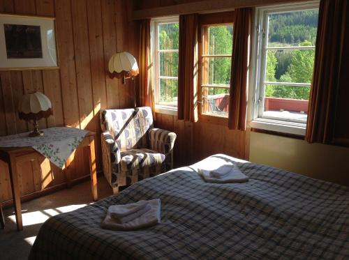 内斯比恩斯美兹加德酒店的一间卧室配有一张床、一把椅子和窗户。