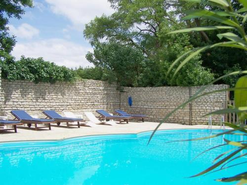 莫雷勒斯Château de l'Abbaye - Teritoria的砖墙旁的游泳池,配有躺椅