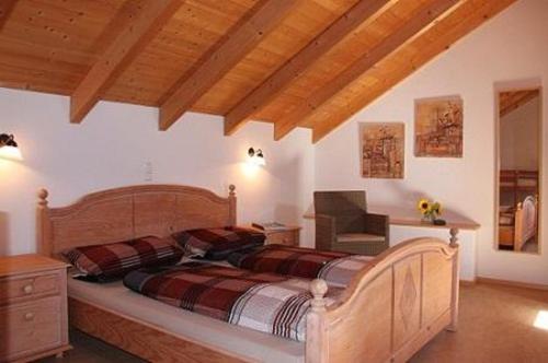 瓦尔德基兴FrongaHOF的一间带一张床的卧室,位于带木制天花板的房间内