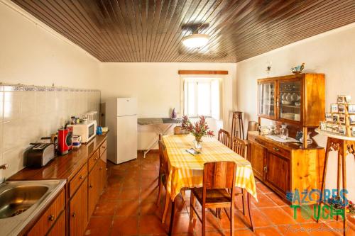 普拉亚达维多利亚Hospedaria casa D'Avo的一间带桌子的厨房和一间餐厅