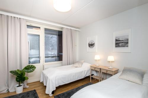瓦萨Kotimaailma Apartments Vaasa的一间卧室设有两张床和窗户。