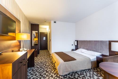 科沃布热格Hotel Solny的配有一张床和一张书桌的酒店客房