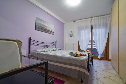萨包迪亚Arcibaleno的一间卧室配有两张床和一张玻璃桌