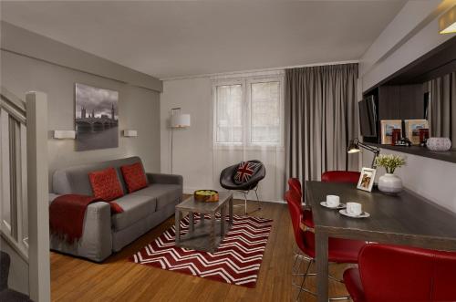 伦敦馨塔迪特拉法加广场酒店的客厅配有沙发和桌子