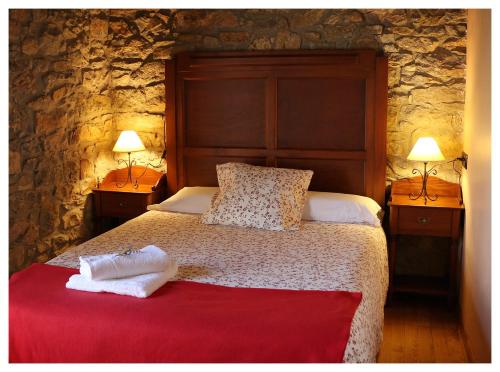 LeiguardaCasa L´Andorvio的一间卧室配有一张大床和两盏灯