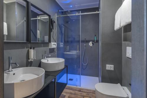 米兰罗克西酒店的一间带两个盥洗盆和淋浴的浴室