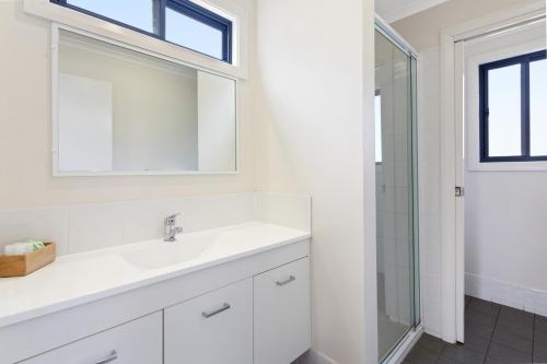 古尔本古尔南大篷车公园酒店的白色的浴室设有水槽和淋浴。
