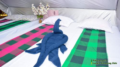 锡吉里亚Sigiri Jungle Camping的床上有蓝色的填充海豚