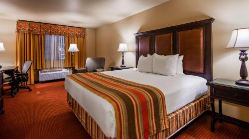 拉雷多圣伊西德罗旅馆贝斯特韦斯特酒店的酒店客房设有一张大床和一张书桌。