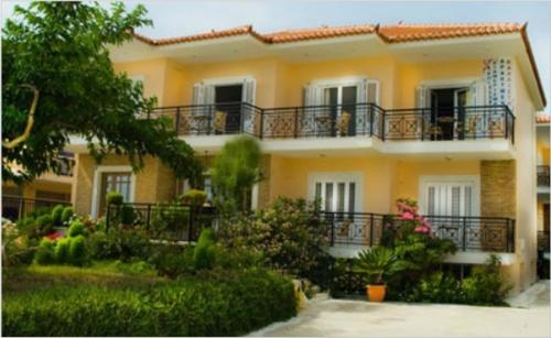 菲尼孔塔卡里斯提旅馆的带阳台和植物的大型黄色房屋