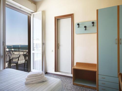 里米尼特尔斯塔酒店的一间卧室设有一张床和一个阳台