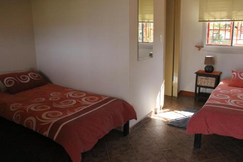 Chausib路易莎沙漠牧场山林小屋的一间卧室设有两张床和窗户。