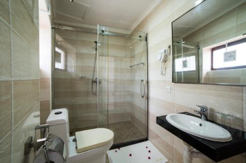 桑给巴尔Antonio Garden Hotel的带淋浴、卫生间和盥洗盆的浴室