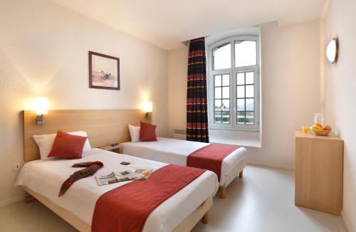 埃佩尔奈Vacancéole - Les Demeures Champenoises的酒店客房设有两张床和窗户。
