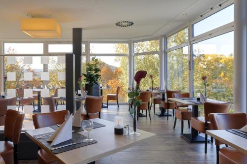 巴特基辛根库普威特利斯酒店的餐厅设有桌椅和窗户。