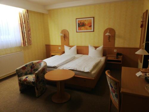 格兰多夫赫本曼豪斯艾利克斯酒店的酒店客房,配有床、桌子和椅子
