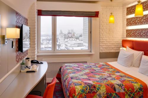 莫斯科韦加-伊兹马伊洛沃酒店的配有一张床、一张书桌和一扇窗户的酒店客房