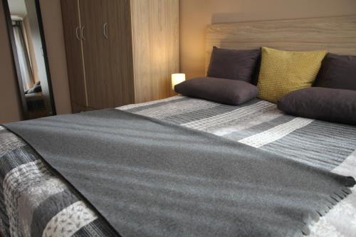 索非亚Apartment 46的卧室配有一张带灰色和黄色枕头的大床